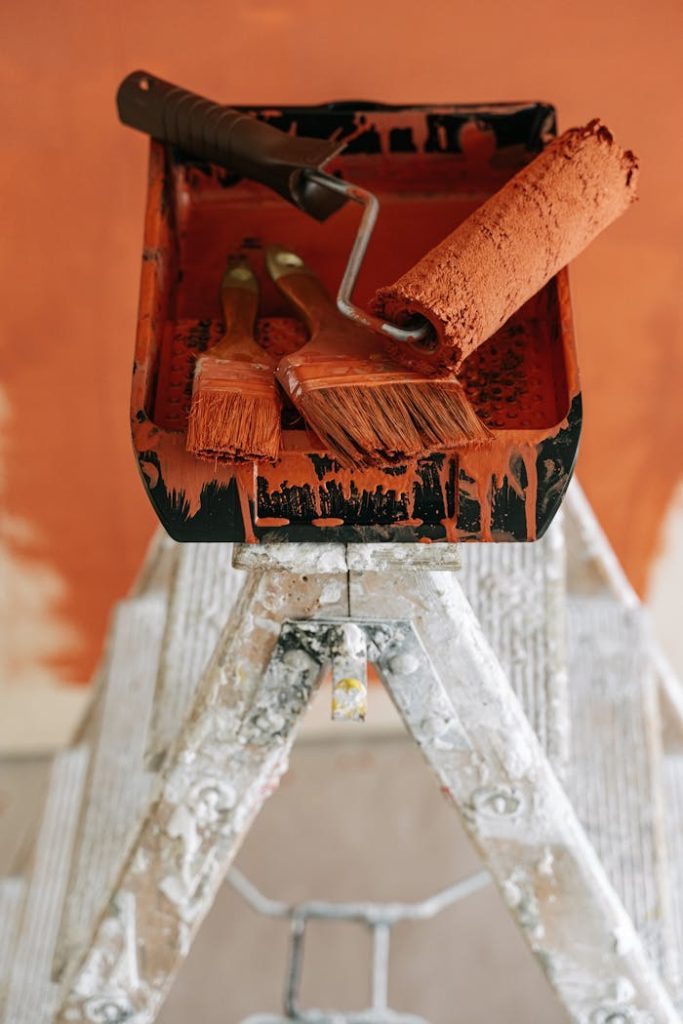painting-materials-on-a-stepladder-5799094 Paint roller and brushes on a ladder tray ready for home renovation.